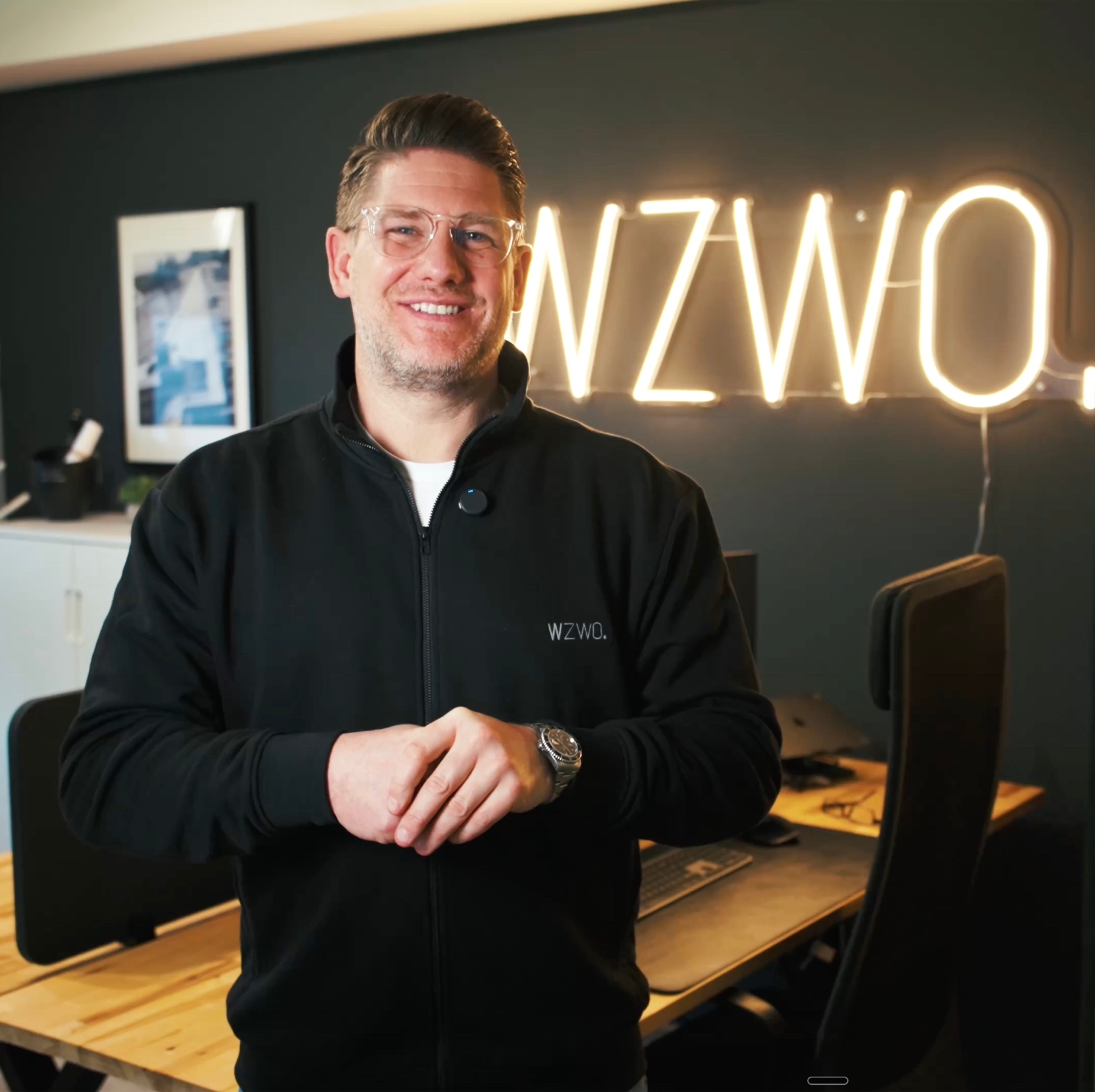 WZWO Geschäftsführer vor dem beleuchteten WZWO Logo